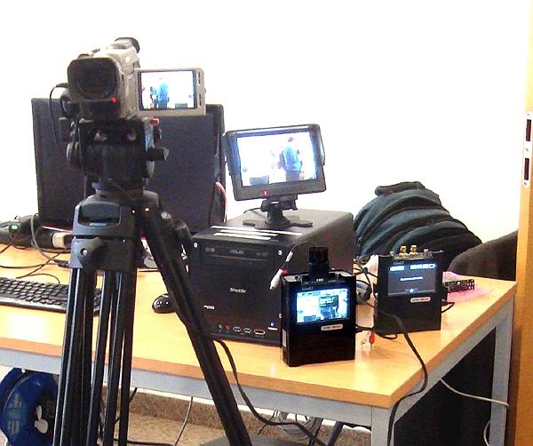  Az asztalon két LiveU40i ácsorog, a bal oldali közvetíti a kamera képét, ami a számítógép tetején levő kis monitoron is látható.