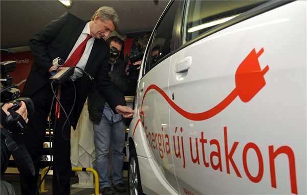 Eric Depluet, az E.ON Hungária Zrt. vezérigazgatója csatlakoztatja a töltéshez szükséges vezetéket egy hibridhajtású   személyautóhoz a győr, Jókai utcai parkolóházban. MTI Fotó: Krizsán Csaba 