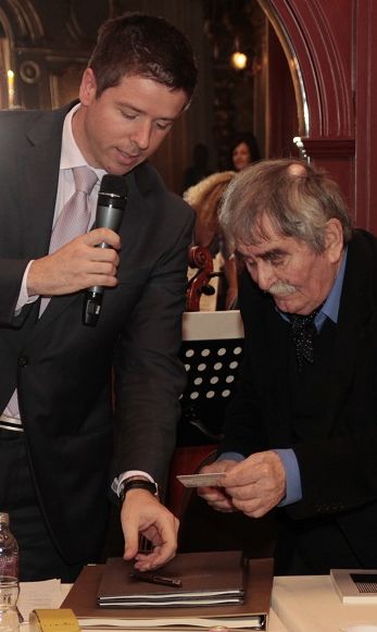Juhász Ferenc átveszi Szabó Csabától az Irodalmi Páholy 1. számú tagsági kártyáját.