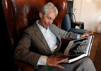 Charlie Watts dobos a jubileumi könyvet nézegeti.