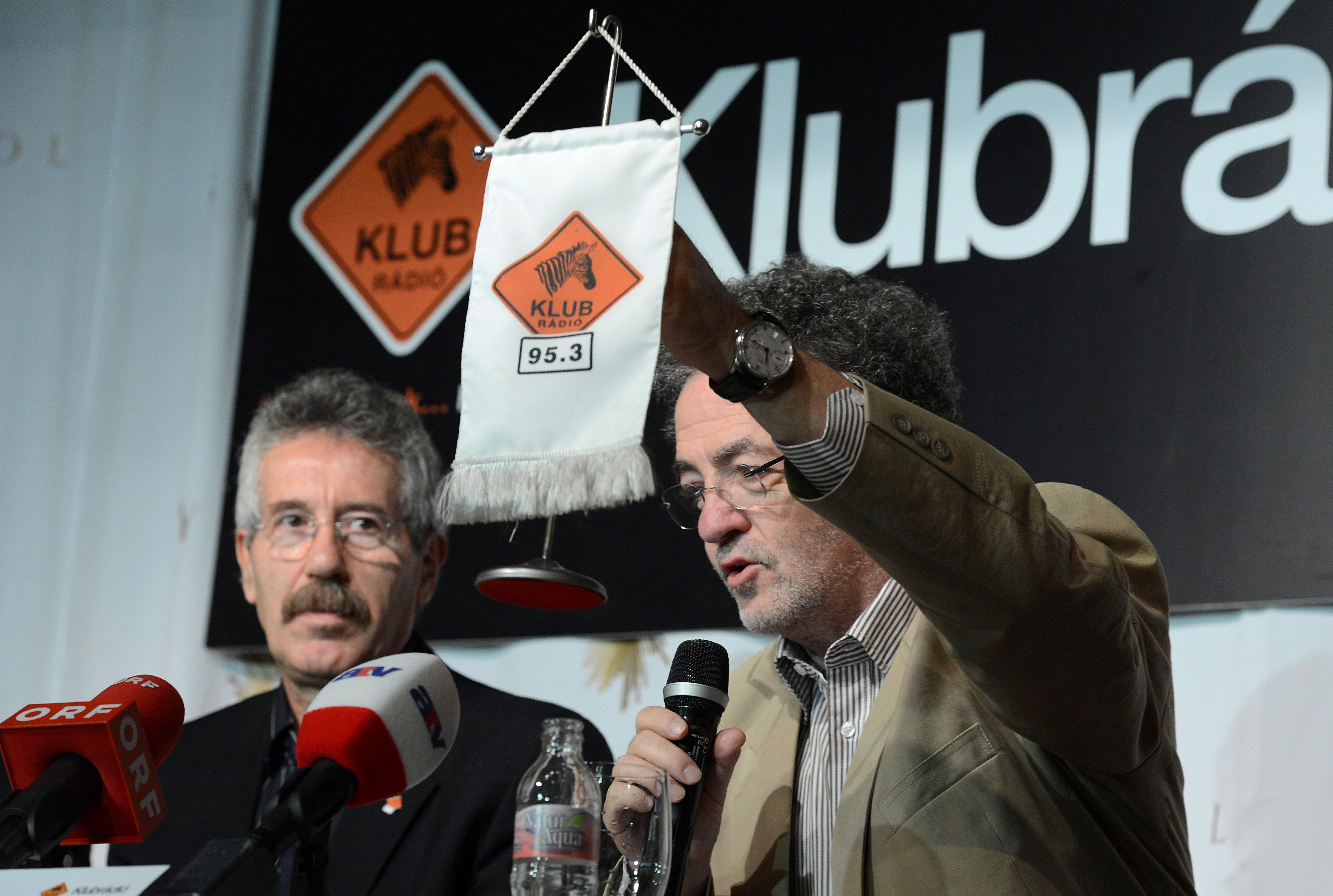 Arató András, a Klubrádió vezérigazgatója (j) mutatja a rádió zászlóját a budapesti Symbol gasztronómiai, szórakoztató és kulturális központban tartott sajtótájékoztatón 2012. november 15-én. Mellette Vicsek Ferenc, a rádió főszerkesztője ül. MTI Fotó: Kovács Tamás 