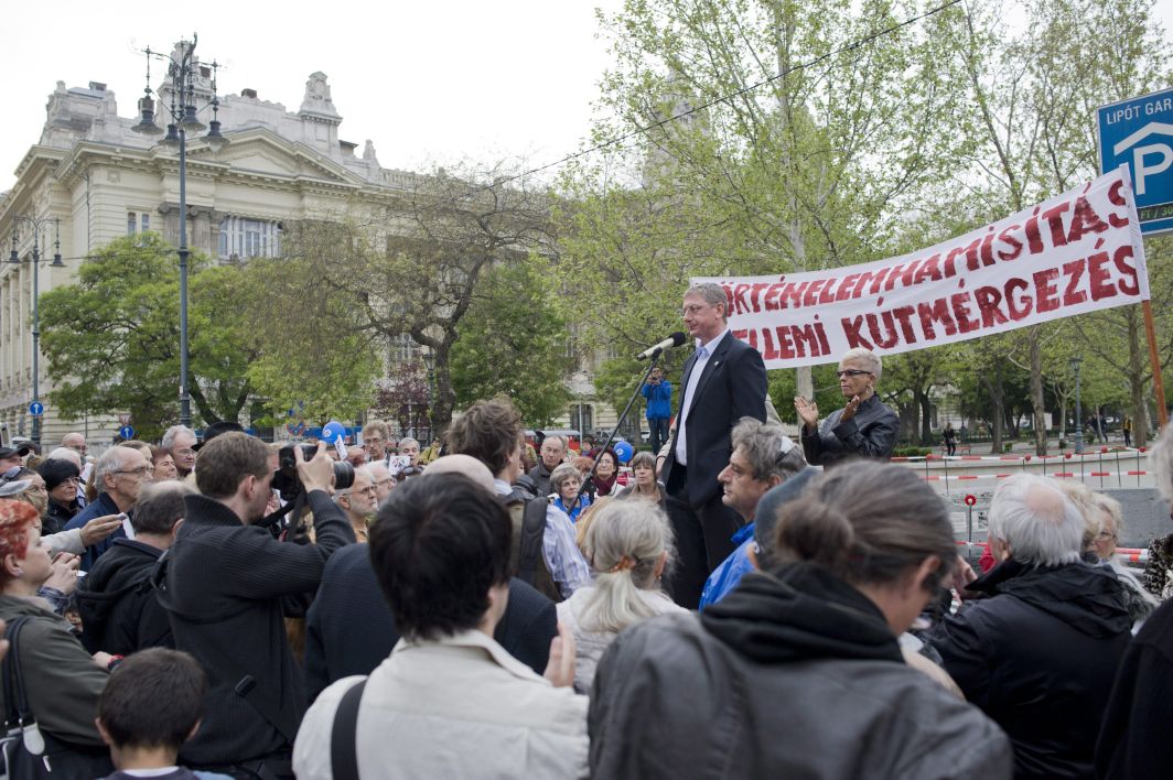 Gyurcsány Ferenc korábbi miniszterelnök, a Demokratikus Koalíció (DK) elnöke beszédet mond 2014. április 13-án a Szabadság térre tervezett, a német megszállás áldozatainak tiszteletére állítandó emlékmű helyénél, ahol tiltakozó civilek a hét eleje óta demonstrálnak, a kordont többször elbontották, amelyet az építők vissza-visszaállították. Április 11-én a tüntetők a tervezett emlékmű talapzatát megbontották. (MTI Fotó: Kallos Bea)
