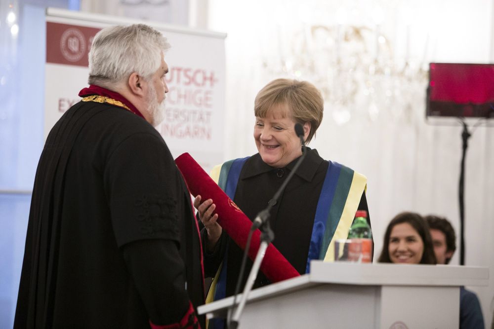 Az Andrássy Gyula Budapesti Német Nyelvű Egyetem által közzétett képen Szabó Gábor, a Szegedi Tudományegyetem rektora átadja egyeteme díszdoktori címét Angela Merkel német kancellárnak Budapesten, az Andrássy egyetemen 2015. február 2-án. (MTI Fotó: Andrássy egyetem/Képszerkesztőség/Ancsin Gábor)