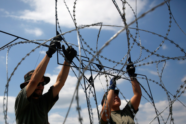A déli vasfüggöny egyik változata: magyar katonák építik a legsúlyosabb sérüléseket okozó pengehuzallal erősített határhálót. (Foto: Darko Vojinovic / Keystone)