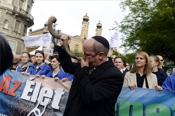 Verő Tamás rabbi a sófár megfújásával elindítja az Élet menetét a Dohány utcai zsinagógánál 2016. április 17-én. Jobbra Colleen Bell, az Egyesült Államok budapesti nagykövete. Az Élet menetét tizennegyedszer tartják meg, hogy a résztvevők felekezeti és politikai hovatartozásra tekintet nélkül együtt róhassák le kegyeletüket a holokauszt áldozatainak emléke előtt, és hitet tegyenek a társadalmi szolidaritás és a demokratikus politikai kultúra mellett. (MTI Fotó: Kovács Tamás)